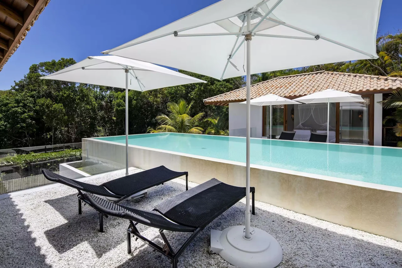 Piscina com borda infinita e espreguiçadeiras, mansão de luxo em Trancoso