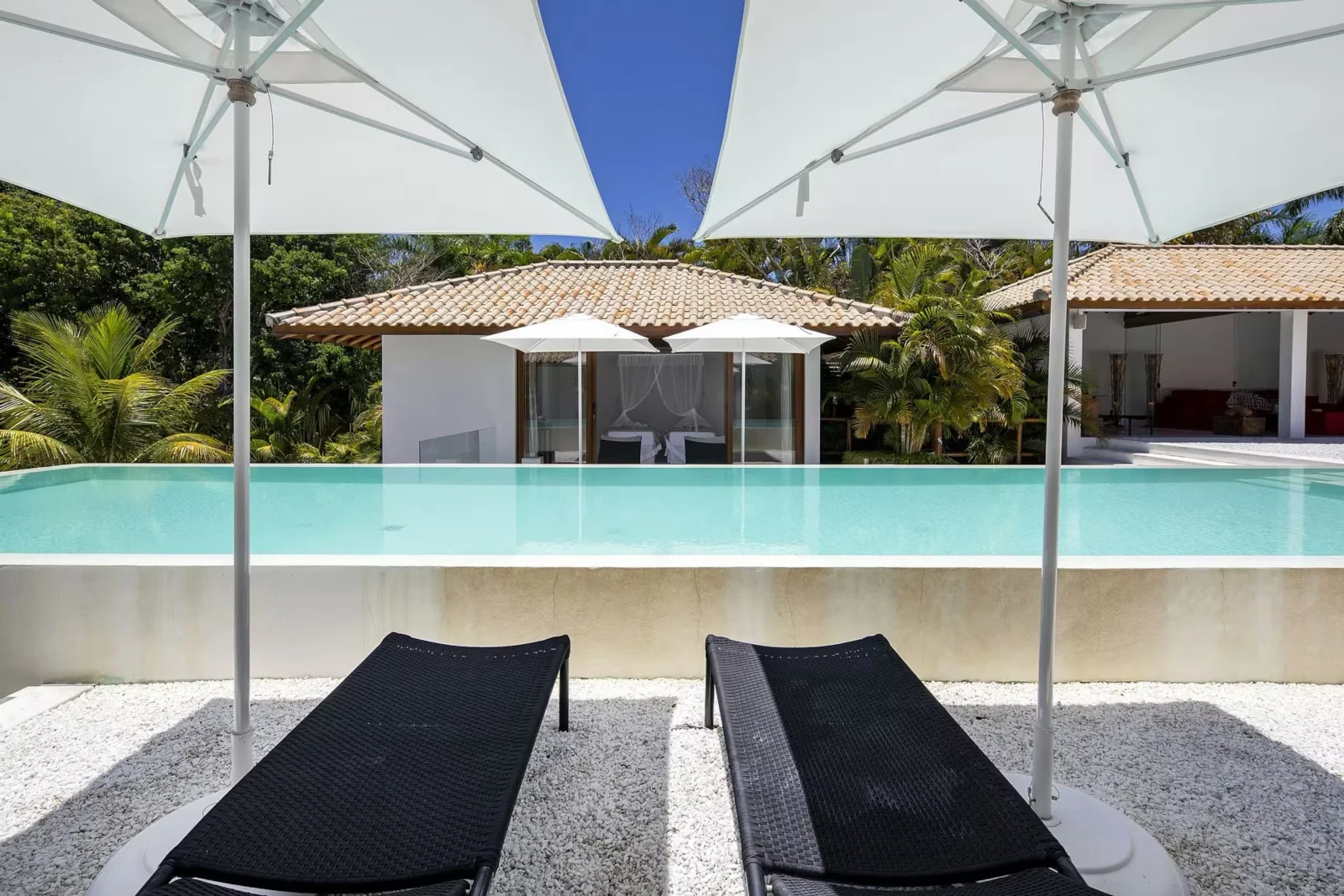 Espreguiçadeiras à beira da piscina, mansão de luxo em Trancoso